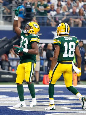 Green Bay Packers running back Aaron Jones (33) and Randall Cobb (18) celebrate a touchdown scored on a run by Jones in the first half of an NFL football game against the Dallas Cowboys on Oct. 8 in Arlington, Texas.