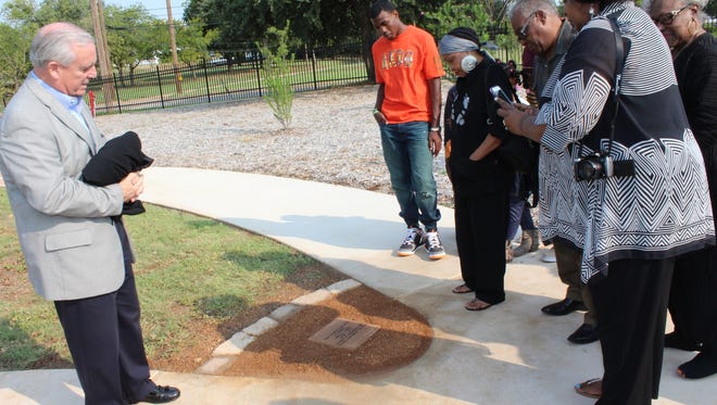 Norm Archibald, representing Hendrick Medical Center Foundation, steps back to admire a stone honoring the late Idella James. Her family, right, get their first look at the marker that honors a woman whose house stood at the site, now a part of the grounds at Hendrick Hospice Care.