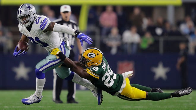 Dallas Cowboys running back Ezekiel Elliott fends off Green Bay Packers safety Kentrell Brice in the second quarter during their NFC divisional playoff game Jan. 15 in Arlington, Texas.