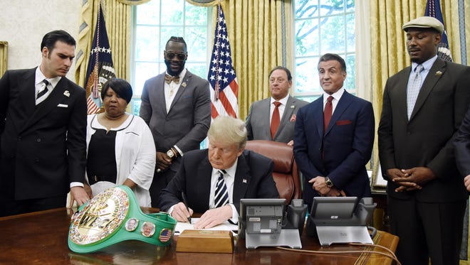 President Trump signs a posthumous pardon for boxer Jack Johnson in the Oval Office of the White House May 24.