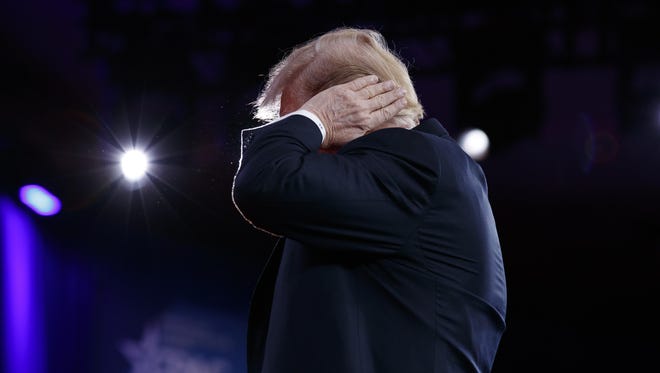 President Donald Trump gestures as he makes a joke about his hair during remarks to the Conservative Political Action Conference, Feb. 23, 2018, in Oxon Hill, Md.