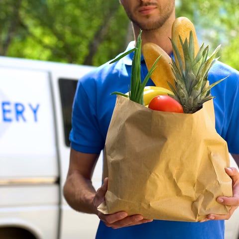 Young man delivering a bag of groceries with the d