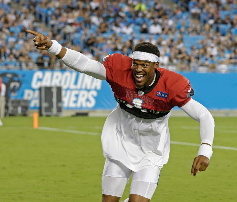 Carolina Panthers quarterback Cam Newton (1) encourages fans to start a wave during a public practice Friday.