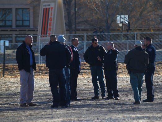 Law enforcement officials and others gather near a