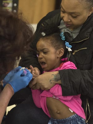 Breeze Harden, 3, breaks into tears as she is tested for lead with her mother Darlene Harden at Eisenhower Elementary in Flint, Michigan on January 26, 2016.