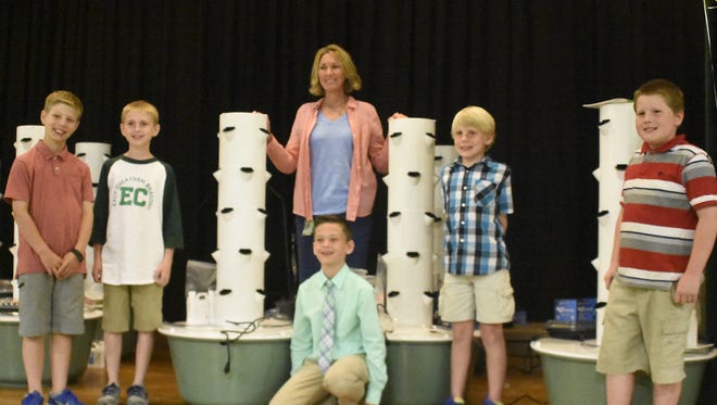 Lacritia Sanson poses with East Cheatham Elementary School students for a photo in front of their aeroponic gardens.