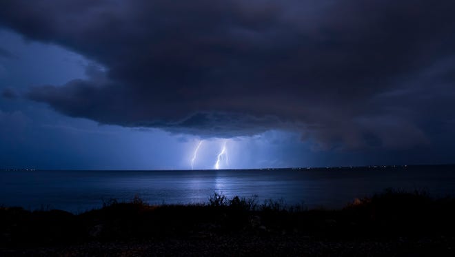 Thunderstorms roll in over Escambia Bay on Sunday night.