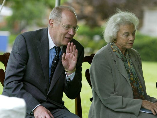 Supreme Court Justice Anthony Kennedy whispers to Justice