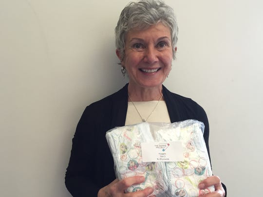 Jan Touslee holds a pack of 12 diapers in this file photo. Touslee co-founded The Nappie Project, a nonprofit diaper bank in Northern Colorado.
