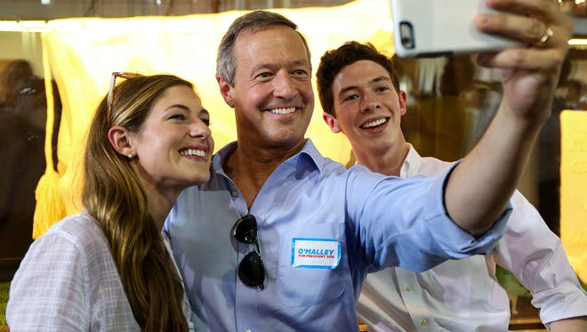 Democratic presidential candidate Martin O'Malley snaps a selfie in front of the Butter Cow at the Iowa State Fair with two of his children, Grace and William, on Thursday, Aug. 13, 2015, in Des Moines, Iowa.