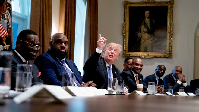 President Donald Trump points up to heaven as he speaks during a meeting with inner city pastors in the Cabinet Room of the White House Wednesday.