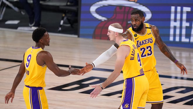 Los Angeles Lakers' LeBron James (23) celebrates with teammates Rajon Rondo (9) and Alex Caruso (4) during the final moments of their win over the Denver Nuggets in the Western Conference Finals on Thursday in Lake Buena Vista, Fla.