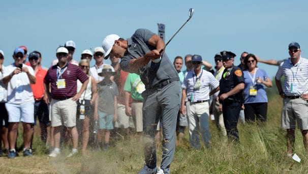 Brooks Koepka hits from the rough on the sixth...