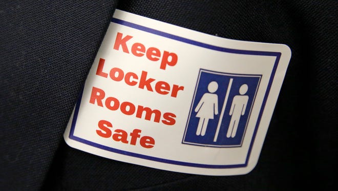In this Jan. 27 file photo, a sticker that reads, "Keep Locker Rooms Safe," is worn by a person supporting a bill that would eliminate Washington's new rule allowing transgender people use gender-segregated bathrooms and locker rooms in public buildings consistent with their gender identity. In clashes over transgender students and which restrooms and locker rooms they should use, the U.S. Department of Education has warned public schools that a sex discrimination law makes it illegal to deny them access to the facilities of their choice.