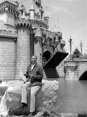 FILE - In this Sunday, July 17, 1955 file photo, Walt Disney sits on a rock in front of the Sleeping Beauty Castle in the Fantasyland section of Disneyland on opening day of the amusement theme park in Anaheim, Calif. A year earlier, Disney made his move. He succumbed to the lure of television and arranged to tie in the TV show (he hosted) with a Disneyland park. (AP Photo)