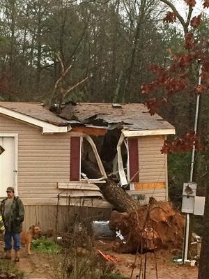 This photo provided by the Pope County Sheriff's Department shows a storm damaged home outside of Atkins, Ark., on Wednesday, Dec. 23, 2015. High winds and heavy rain caused a large tree to become uprooted and fall on the house resulting in the death of an 18-year-old woman and trapping her 1-year-old child inside, authorities said. Rescuers pulled the toddler safely from the home. (Pope County Sheriff's Department photo via AP)