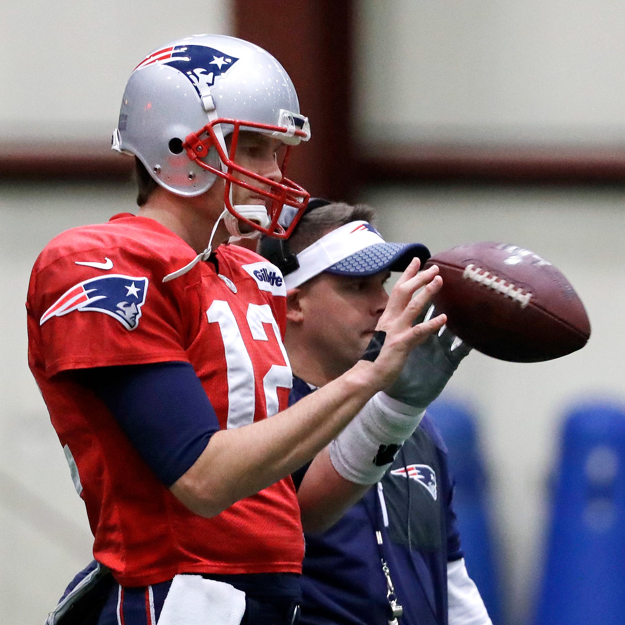 New England Patriots quarterback Tom Brady checks out a football at practice before last season's Super Bowl.