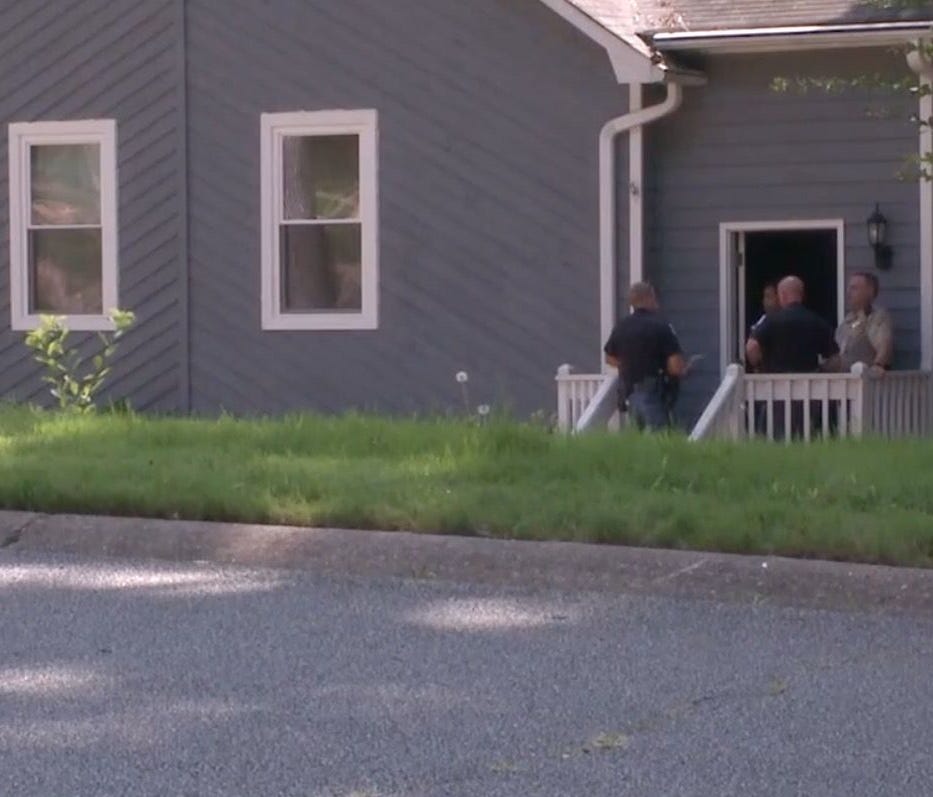 Officers stand outside the home in Marietta, Ga.