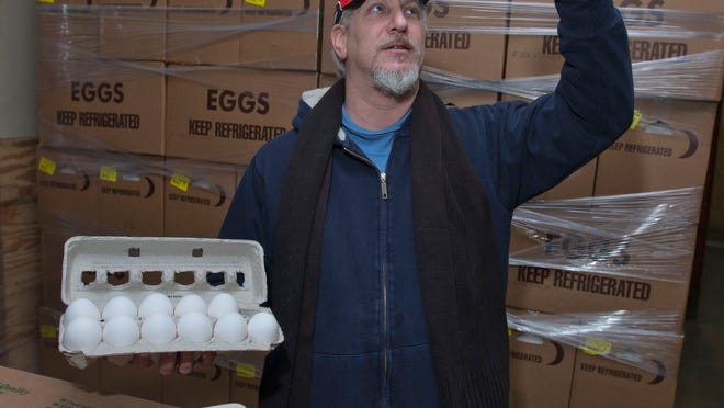 Robert Schuster, owner of Schuster’s Poultry Farm in Lakewood, checks out one of his large eggs.