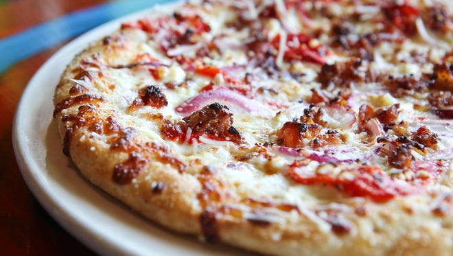 The Lou Lou pizza has a garlic butter sauce with red onion, roasted red pepper, bacon and sun-dried tomato plus mozzarella and goat cheese.