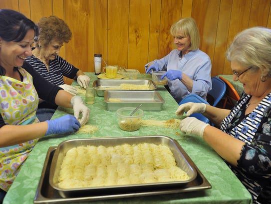 In this file photo, Alexandra Loukou, left, Anthea Atalis, Eleni Moshtaghi and Flora Ataliotism, right, prepare batches of Kataifi at the Holy Cross Greek Orthodox Church. The ladies are preparing for the church's annual Greek Bake Sale Saturday.
