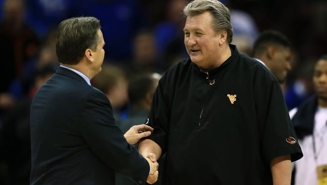 West Virginia Mountaineers head coach Bob Huggins greets Kentucky Wildcats head coach John Calipari after their game in the semifinals of the Midwest Regional of the 2015 NCAA Tournament at Quicken Loans Arena.