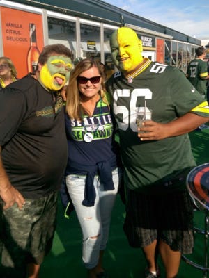 Seahawks fan Kimberly Russell poses with a pair of Packers fans outside Lambeau Field.