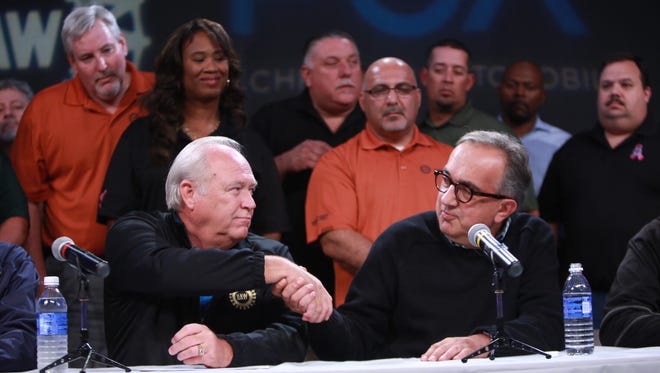UAW President Dennis Williams and FCA CEO Sergio Marchionne shake hands while speaking during a press conference in the auditorium of the UAW-Chrysler NTC Building in Detroit after the UAW announced Tuesday that it has reached a tentative agreement with FCA US LLC.