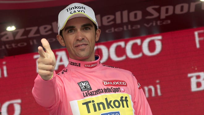 Spanish rider Alberto Contador celebrates the pink jersey of the overall leader on the podium of the 14th stage of the 98th Giro d'Italia.