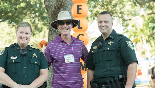Officers from the Lee County Sheriff's Department pose for a photo with a volunteer at Hope Lutheran Church's 2016 Harvest Festival in Bonita Springs.