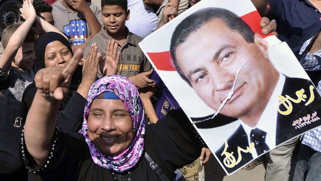An Egyptian supporter of former Egyptian President Hosni Mubarak raises up his portrait outside the Tora prison where Mubarak has been detained, on August 22, 2013.