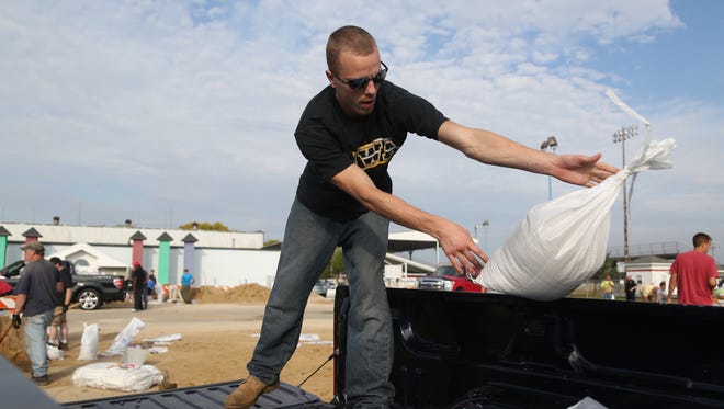 Justice Saylor, 24 of Shellsberg, fills a truck bed with sandbags on Sunday, Sept. 25, 2016, in the parking lot of Hawkeye Downs in Cedar Rapids.