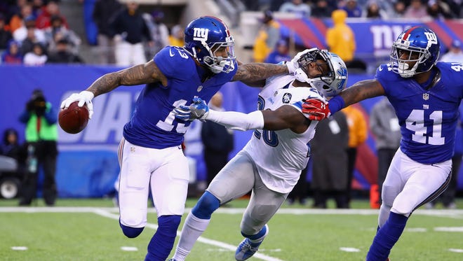 Giants receiver Odell Beckham carries the ball as he escapes a tackle from Lions safety Don Carey in the second half at MetLife Stadium on Dec. 18, 2016 in East Rutherford, N.J.