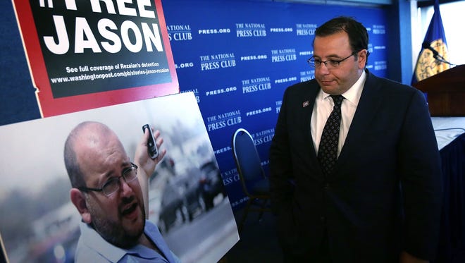 Ali Rezaian looks at a picture of his brother, Washington Post Tehran bureau chief Jason Rezaian, after a news conference at the National Press Club July 22, 2015, in Washington on Jason's detention in Iran.