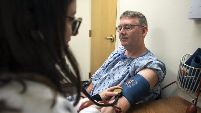 Nurse practitioner Patricia Scanlon takes the blood pressure of Jeff Foster during his September 2018 appointment at the Framingham Heart Study Clinic.