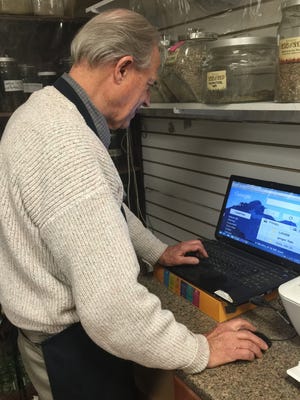 Gerald Sinclair of Rosemary's Herb Shop, 1705 Sudderth Drive, checks the store's website.