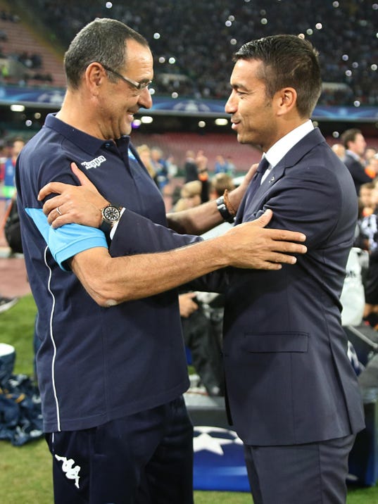 Napoli's coach Maurizio Sarri, left, greets Feyenoord's coach Giovanni van Bronckhorst prior to the Uefa Champions League, Group F soccer match between Napoli and Feyenoord at the San Paolo stadium in Naples, Italy, Tuesday, Sept. 26, 2017. (Cesare Abbate/ANSA via AP)