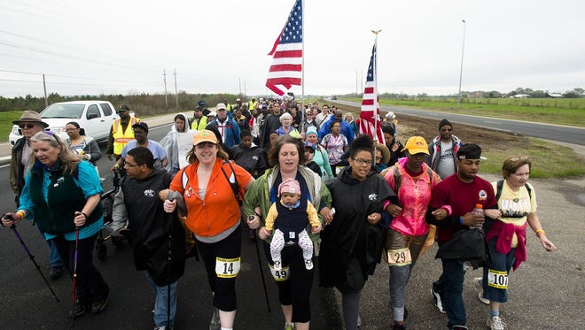 Marchers walk off the main road for a break while participating in a commemorative march of the 1965 Selma to Montgomery March as part of the National Parks Service 50th Anniversary Walking Classroom outside of Selma, Ala., on Saturday, March 21, 2015. Marchers walk 12.9 miles on Sunday stopping ending at Lowndes Interpretive Center.