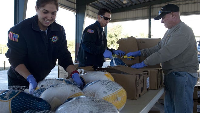 Volunteers with the Big Heart Brigade of the Treasure Coast volunteers, mostly Indian River County Fire Rescue firefighter paramedics and family members, prepare Thanksgiving turkeys for needy families on Nov. 21, 2016, at the Indian River County Fairgrounds in Vero Beach.