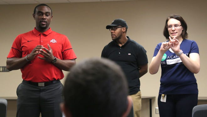 Former Ohio State football players Nick Patterson (left) and Tyler Everett give a talk through sign langue interpreter, Tanya Haga, to deaf children about overcoming challenges. The athletes represented the Driven Foundation at Catalyst Life Services during Thursday's community outreach program.
