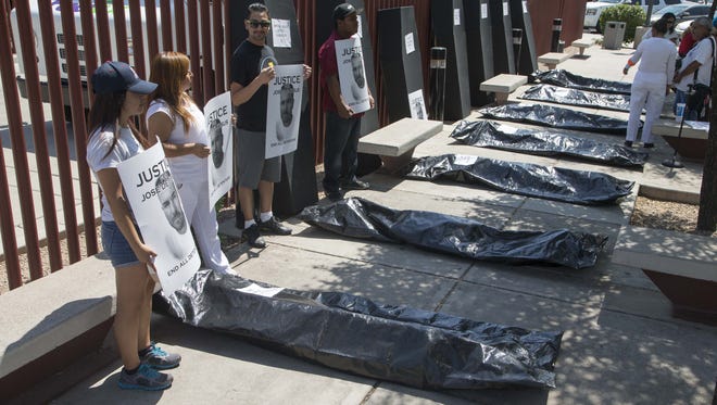 Activist group Puente of Arizona bring coffins and body bags in front of ICE  to represent the deaths in immigration detention centers around Arizona. Thursday, August 20, 2015.