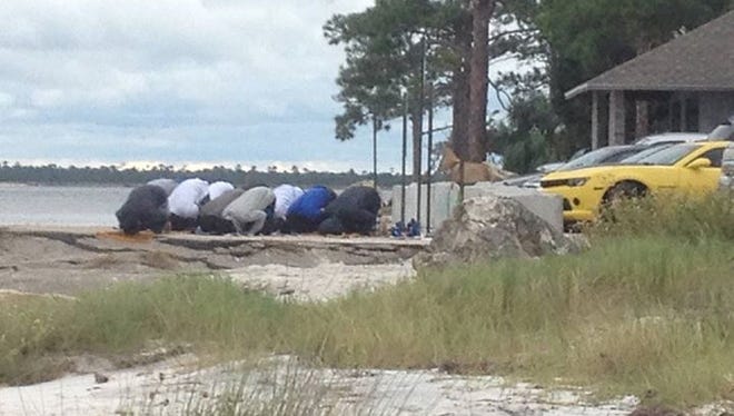 Vanessa Moore's 29-year-old son and friends praying at Mashes Sands beach last weekend. Moore is criticizing local radio host Will Dance for questioning the group's motives.