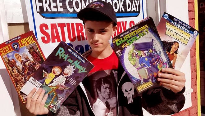 Funnybooks employee Kevin Otto holds some of the selections from this year's Free Comic Book Day.