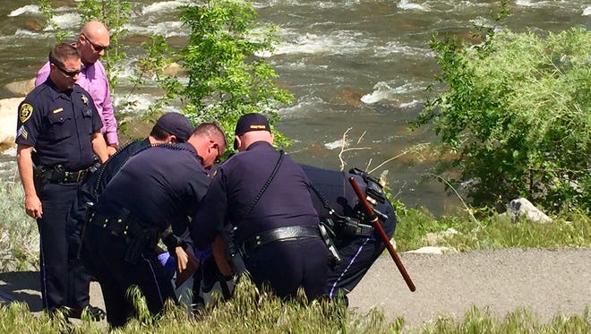 Reno police help a man on the banks of the Truckee River east of downtown on Thursday, May 12, 2016.