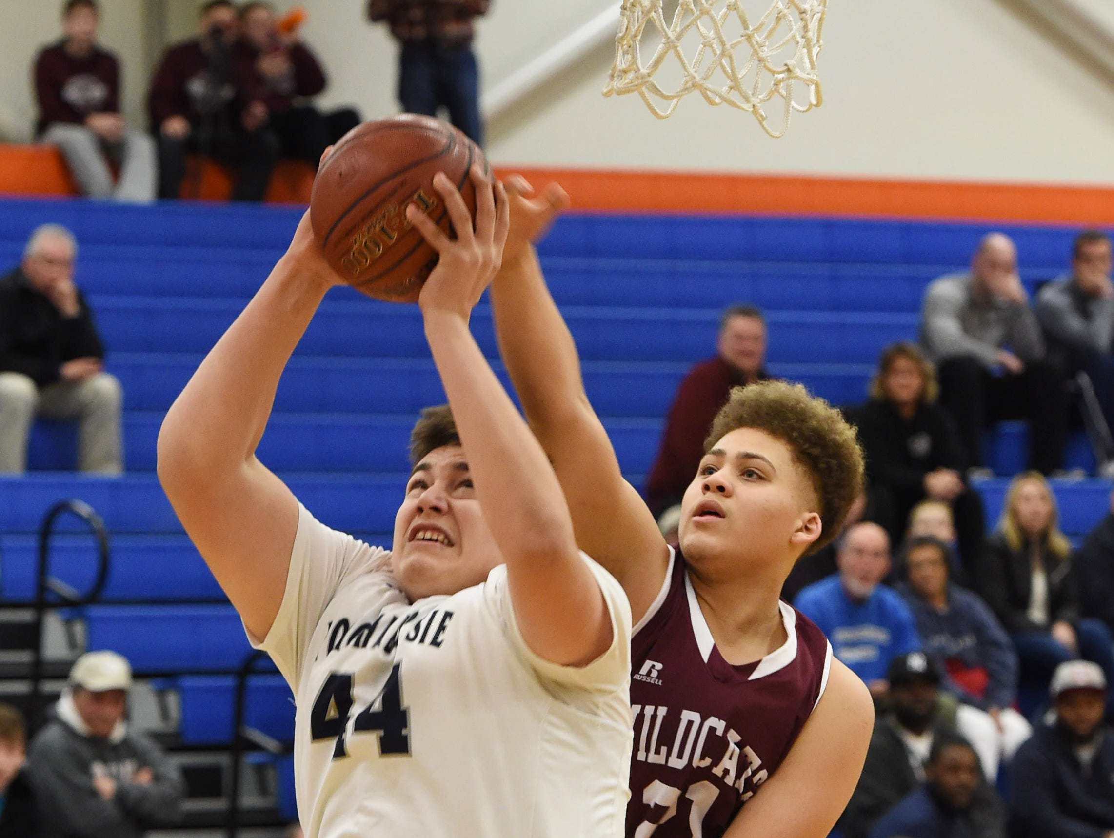 Poughkeepsie's Corey Simmons, left, goes for a layup as Johnson City's Xavier Hill, right, defends during the Class A regional semifinal game at SUNY New Paltz.