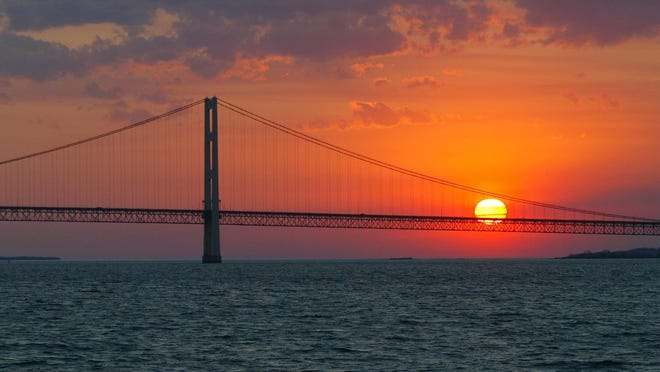 FILE - In this May 31, 2002 file photo, the sun sets over the Mackinac Bridge and the Mackinac Straits as seen from Lake Huron. The bridge is the dividing line between Lake Michigan to the west and Lake Huron to the east. President Donald Trump again is trying to drastically reduce or eliminate federal support for cleanups of some iconic U.S. waterways. His proposed budget would slash Environmental Protection Agency funding for Great Lakes and Chesapeake Bay restoration programs by 90 percent. It would kills all EPA spending on programs supporting other waters including San Francisco Bay, the Gulf of Mexico and Puget Sound. The administration made a similar attempt last year but Congress refused to go along. (AP Photo/Al Goldis, File)