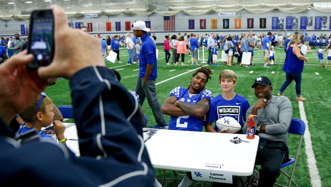 UK wide receiver Dorian Baker and wide receiver coach Lamar Thomas pose for a photo with a fan during UK Football Fan Day in Lexington, Ky., on Saturday, August 5, 2017.