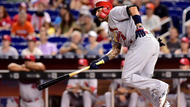 St. Louis Cardinals catcher Yadier Molina takes off for first base as he hits a double during the second inning against the Miami Marlins on Thursday.