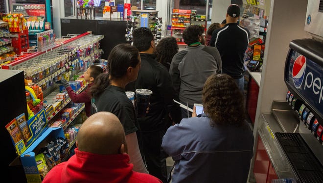 Customers throng to the Pic Quik convenience store on Missouri Avenue on to buy Powerball lottery tickets. The estimated jackpot for the drawing on Wednesday night is expected to to reach a record high of $1.5 billion.