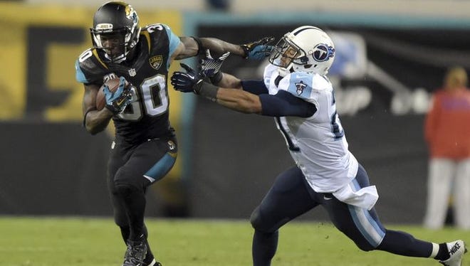 Jaguars running back Jordan Todman (30) is pursued by Titans safety George Wilson (21) on a 62-yard touchdown run in the fourth quarter.